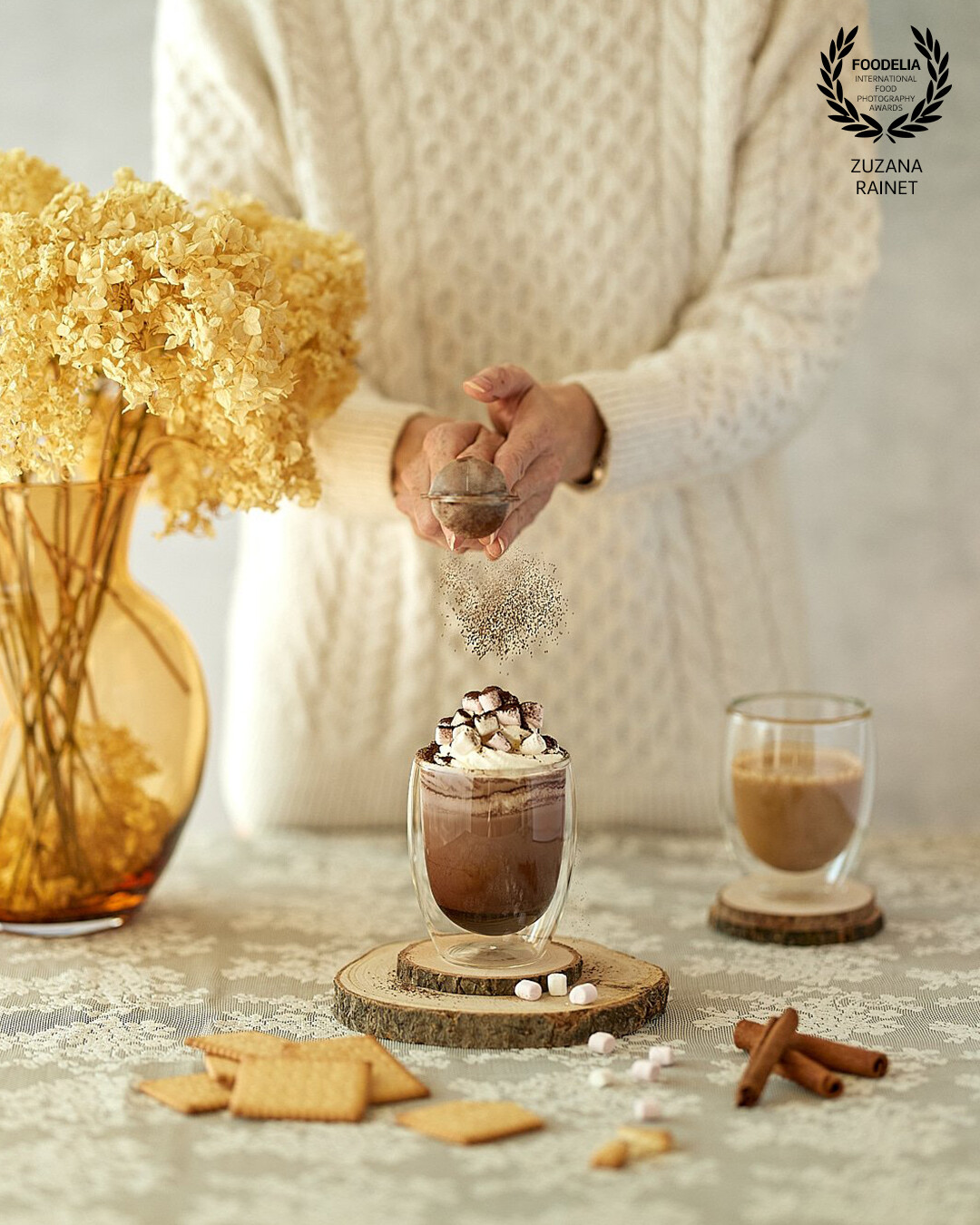 In this photoshoot I wanted to capture the frozen movement of cocoa powder falling on a hot chocolate served with cream and marshmallows. The image should evoke the cosy winter atmosphere. Shot with natural light.