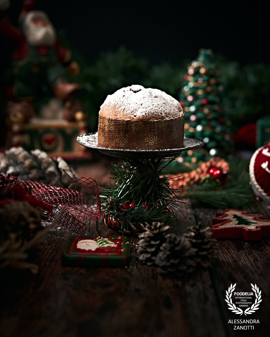 This photograph captures the festive atmosphere of Christmas. The decorations create a warm and welcoming setting, spreading the magic and joy of the holidays. At the center of the scene is a delightful panettone, a symbol of Christmas tradition and sweetness. An image that celebrates the warmth and joy of Christmas, with the panettone embodying the shared pleasure during this special season.
