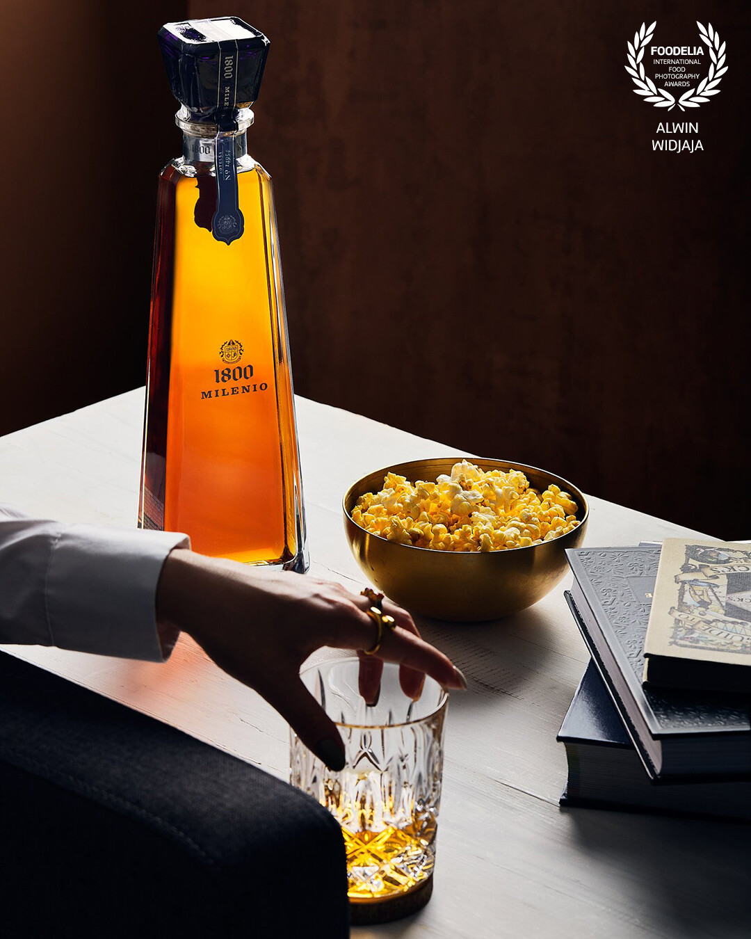 The client asked for an elegant setting for this 1800 Tequila, so I set about transforming a small corner of their office into cozy, home lounge. I imagined light from a large window sweeping across this space during golden hour as someone is settling down for glass of tequila after a day in of work.
