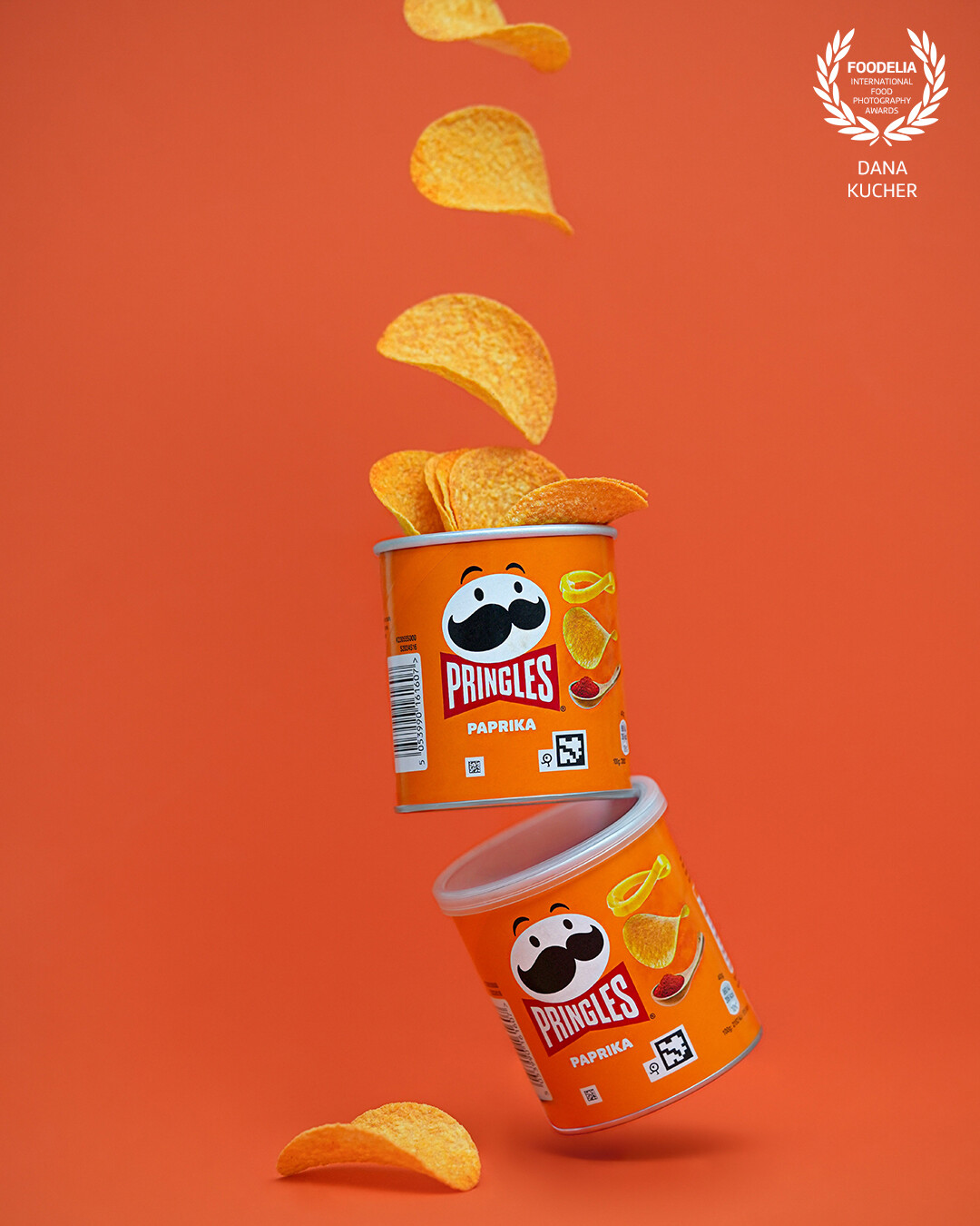 Light & Crispy Magic<br />
Pringles chips in a weightless dance! Perfectly balanced paprika-flavored cans seem to float in space, while crispy slices soar through the air as if obeying the law of taste. The deep orange background enhances the richness of the flavor, adding energy and dynamism to the image. These aren’t just snacks – they’re moments of pure enjoyment in every