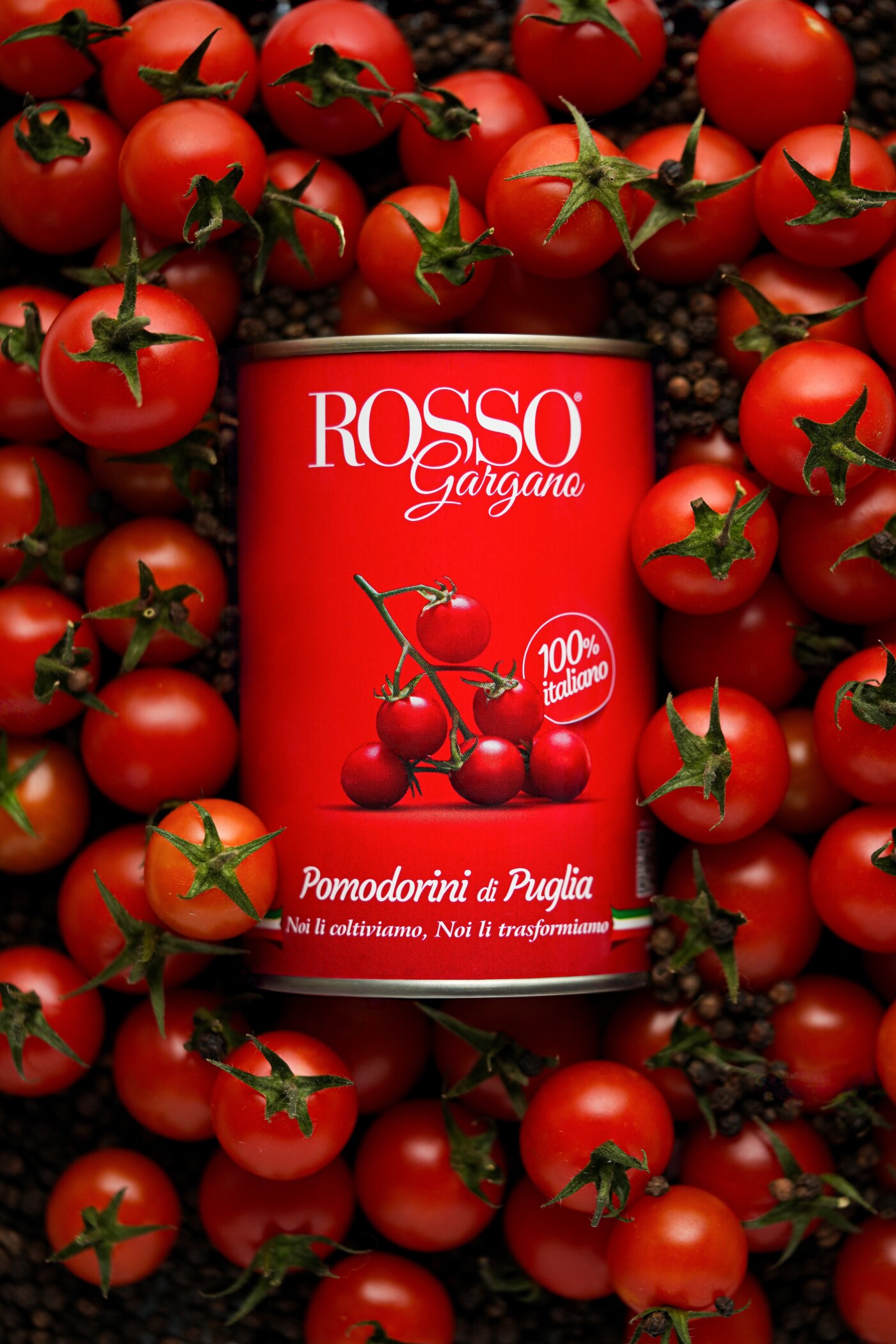 Ripe cherry tomatoes burst from the tin in an explosion of texture and color, lit by gentle side lig...