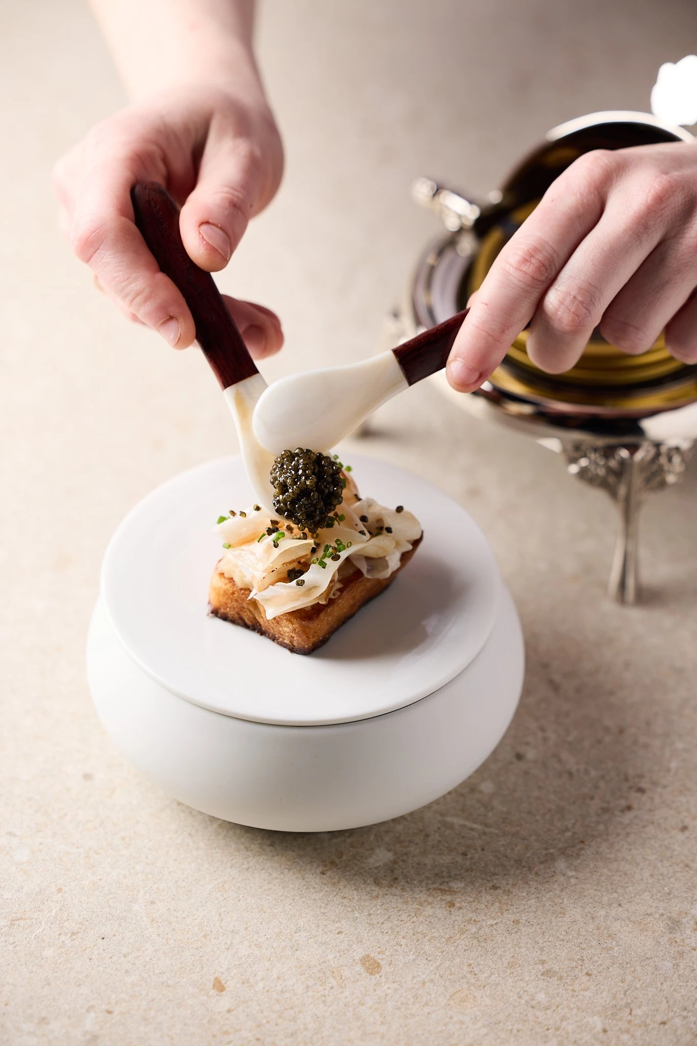 A lukewarm brioche with compote of Cévennes onion, guanciale and Imperial Heritage caviar. Shot at r...