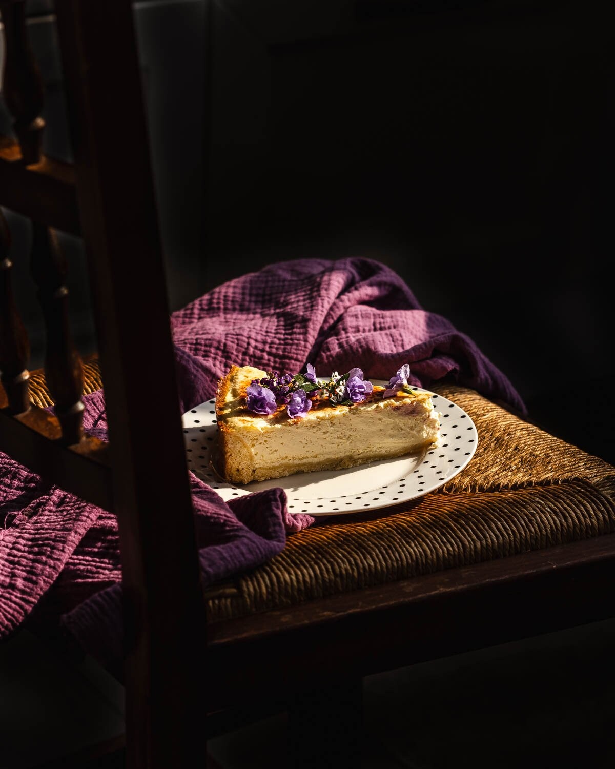 A slice of a home-baked cheesecake with a seemingly unintentional serving on a rustic chair. A sweet...