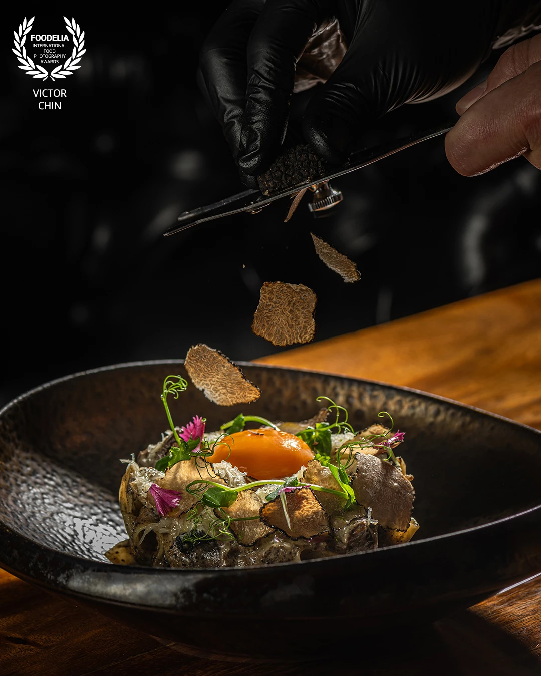 This image captures the luxurious essence of fine dining, freezing the exact moment truffle shavings fall onto a meticulously plated dish. Shot with controlled lighting to enhance texture, motion, and contrast, the composition draws attention to the vibrant yolk, delicate garnishes, and the rich texture of fresh truffle. As a food photographer based in Malaysia, my goal was to highlight the artistry behind premium ingredients and translate culinary craftsmanship into a visually indulgent experience.