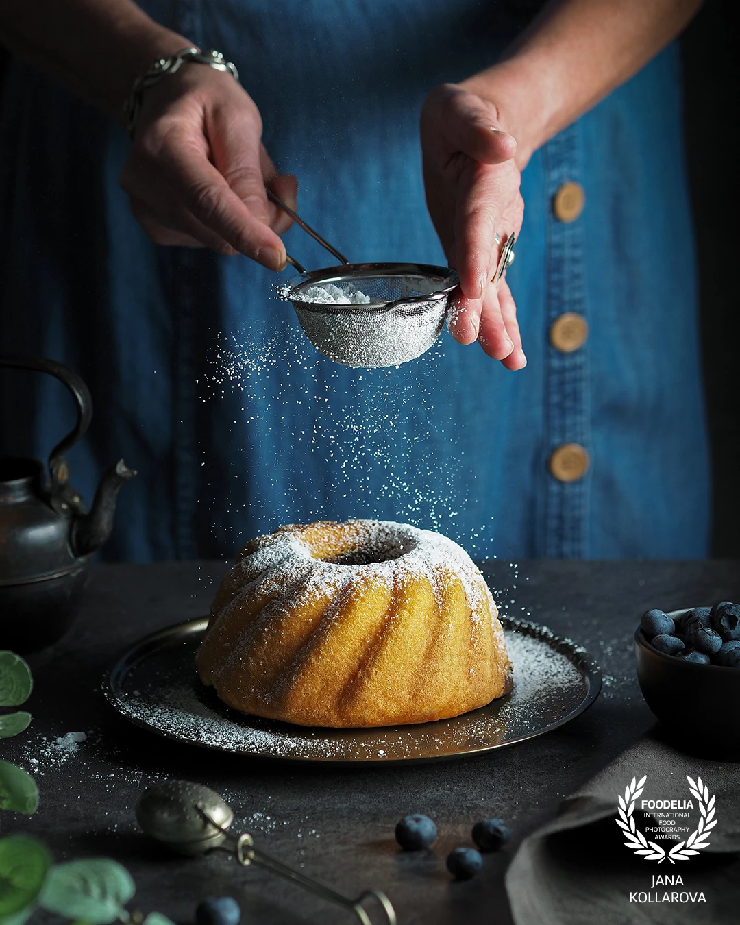 A moment of simple comfort — golden bundt cake dusted with sugar, soft light revealing its gentle texture and warmth. A quiet tribute to the timeless charm of homemade comfort food, where every crumb carries a memory.