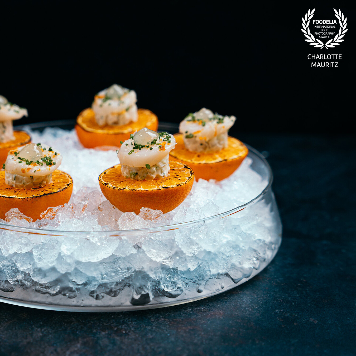 This amuse is part of the spring menu from high end cater famous flavours. It’s burned tangerine | scallops | chives served on ice.