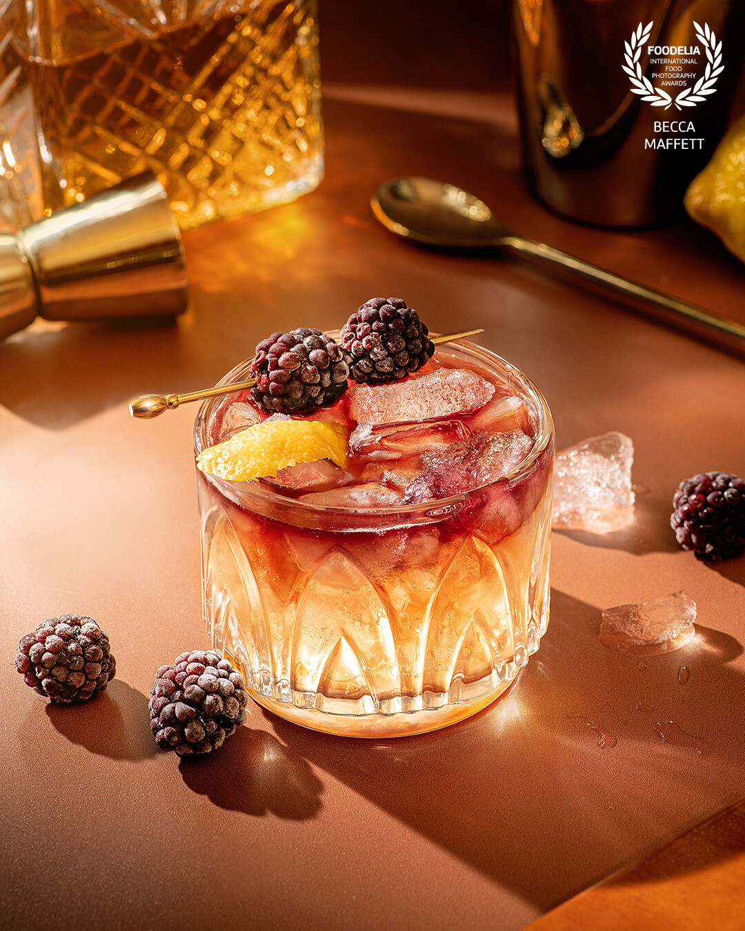 A new york sour in the spotlight with a frozen blackberry garnish.